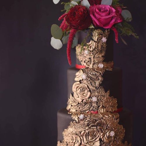 3 layer chocolate wedding cake with gold trim and red roses on top